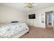 Bedroom with carpet flooring, modern wall-mounted television, and ensuite bathroom access at 2080 Silver Breeze Ave, Las Vegas, NV 89183