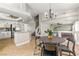 Open concept dining area with tile floors, modern chandelier, and views of the kitchen and living room at 2080 Silver Breeze Ave, Las Vegas, NV 89183