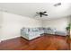 Bright living room featuring a large grey sectional, hardwood floors, and modern ceiling fan at 2080 Silver Breeze Ave, Las Vegas, NV 89183