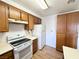 Traditional kitchen featuring wood cabinets, white appliances, and tile flooring at 2160 Highpointe Dr # 102, Laughlin, NV 89029