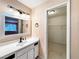 Bright bathroom featuring a single sink vanity, decorative mirror, and a spacious walk-in closet at 2204 Short Pine Dr, Las Vegas, NV 89108