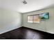 Bedroom with dark hardwood floors, a window for natural light, and a mounted television at 2204 Short Pine Dr, Las Vegas, NV 89108