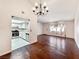 Open living room with hardwood floors, a classic chandelier, and a pass-through to the kitchen at 2204 Short Pine Dr, Las Vegas, NV 89108