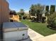 Lush backyard featuring manicured lawn, a wood deck, and a relaxing hot tub, ideal for outdoor living at 2728 Aspen Wood Ave, Henderson, NV 89074