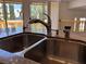 Stainless steel sink with granite countertops, large windows, and backyard view at 2728 Aspen Wood Ave, Henderson, NV 89074