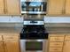 Modern stainless steel stove and microwave combination with wooden cabinets at 2728 Aspen Wood Ave, Henderson, NV 89074