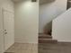 Entryway with tile flooring, leading to carpeted stairs and a door on the left at 3021 New Journey Way, North Las Vegas, NV 89031