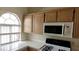 Kitchen featuring light cabinets, microwave, gas range and window providing natural light at 3125 N Buffalo Dr # 2104, Las Vegas, NV 89128