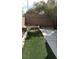A concrete patio next to a small strip of backyard with block wall and a mature tree at 3644 Starlight Evening St, Las Vegas, NV 89129