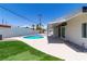 Backyard featuring a sparkling pool, artificial grass, and covered patio perfect for outdoor entertaining at 3647 Ottawa Cir, Las Vegas, NV 89169