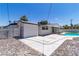 Spacious backyard featuring a sparkling pool, storage shed, and concrete patio area at 3647 Ottawa Cir, Las Vegas, NV 89169