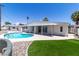 Backyard with a sparkling pool, artificial grass, landscaping, and covered patio area for outdoor living at 3647 Ottawa Cir, Las Vegas, NV 89169