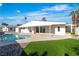 View of the backyard featuring a covered patio area and a private pool surrounded by rock features at 3647 Ottawa Cir, Las Vegas, NV 89169