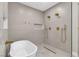 Stylish bathroom with freestanding tub, dual shower heads, and neutral tile at 3647 Ottawa Cir, Las Vegas, NV 89169