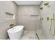 Modern bathroom with freestanding tub, dual shower heads, and neutral tile at 3647 Ottawa Cir, Las Vegas, NV 89169