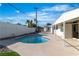 Backyard features a cool pool with a tiled border, surrounded by a concrete patio and lush green landscape at 3647 Ottawa Cir, Las Vegas, NV 89169