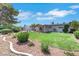 View of a landscaped backyard with a covered patio and well-maintained lawn at 415 Emerald Cir, Henderson, NV 89002