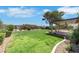 Manicured backyard featuring a covered patio and lush green lawn at 415 Emerald Cir, Henderson, NV 89002