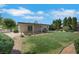 Well-maintained backyard with a covered patio, grassy area, mature trees, and rock landscaping at 415 Emerald Cir, Henderson, NV 89002