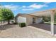 Side view of a backyard with covered patio, gravel landscaping, and mature tree at 415 Emerald Cir, Henderson, NV 89002