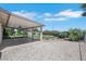 Spacious backyard featuring a covered patio, lush green lawn, and low-maintenance gravel landscaping at 415 Emerald Cir, Henderson, NV 89002