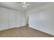 A bright bedroom with wood-look flooring, neutral walls, a ceiling fan and a closet with sliding doors at 415 Emerald Cir, Henderson, NV 89002