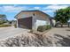 Close-up of a house exterior with a garage, xeriscaping, and partial fencing at 415 Emerald Cir, Henderson, NV 89002