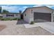 Home exterior featuring a two-car garage, minimalist landscaping, and a concrete pathway at 415 Emerald Cir, Henderson, NV 89002