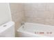 Bathroom features beige-tiled walls, a white bathtub and faucet at 4382 Pinegrove St, Las Vegas, NV 89147