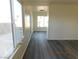 Sunlit living room with grey laminate flooring, large windows providing ample natural light, freshly painted white walls at 4382 Pinegrove St, Las Vegas, NV 89147