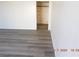 Freshly painted living room showcasing the new grey laminate flooring and a glimpse into an adjacent room at 4382 Pinegrove St, Las Vegas, NV 89147