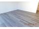 Bright living room with new gray laminate flooring and fresh white walls; ready for your personal touch at 4382 Pinegrove St, Las Vegas, NV 89147