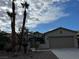 Charming single-story home with desert landscaping and mature palm trees under a partly cloudy sky at 5049 Alfingo St, Las Vegas, NV 89135
