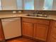 View of the kitchen sink with a dishwasher, hardwood floors, and granite countertops at 5049 Alfingo St, Las Vegas, NV 89135
