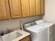 Bright laundry room with cabinets, a sink, and modern washing machines at 5049 Alfingo St, Las Vegas, NV 89135