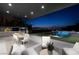 This backyard features a dining area, outdoor kitchen, and a sculpture in the pool at 523 Overlook Rim Dr, Henderson, NV 89012