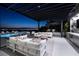 Elegant outdoor lounge area with modern furnishings, a pool, and stunning city views at twilight at 523 Overlook Rim Dr, Henderson, NV 89012