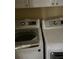 Close-up of a white front-load washer and dryer set with overhead cabinets at 533 Via Santiago St, Las Vegas, NV 89144