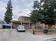 Inviting two-story home with mature trees and a long driveway on a partially cloudy day at 5417 Seabaugh Ave, Las Vegas, NV 89107