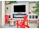 Inviting backyard entertainment area with a modern fireplace, large screen TV and Adirondack chairs at 5553 Coral Gate St, Las Vegas, NV 89148