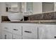 Close-up of a bathroom vanity with white cabinets and a granite countertop and modern bowl sink at 5553 Coral Gate St, Las Vegas, NV 89148