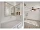 Bathroom with white vanity and a view into a bedroom with light wood flooring and ceiling fan at 5553 Coral Gate St, Las Vegas, NV 89148