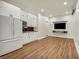 Bright living area with modern kitchenette, laminate flooring, and a wall-mounted TV at 5553 Coral Gate St, Las Vegas, NV 89148