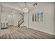Spacious living room with wood-look flooring, white walls, staircase and modern chandelier at 5553 Coral Gate St, Las Vegas, NV 89148