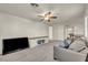 Comfortable living room with gray sofa, media center, and ceiling fan at 5553 Coral Gate St, Las Vegas, NV 89148