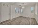 Inviting living room features wood-look floors, white walls, shuttered windows, and contemporary light fixture at 5553 Coral Gate St, Las Vegas, NV 89148