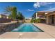 Inviting backyard featuring a pool with a serene water feature, lush greenery, and a spacious patio at 5576 Buena Martina Way, Las Vegas, NV 89141
