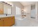 Bright bathroom featuring a soaking tub, double vanities, and walk-in shower with marble-look flooring at 5576 Buena Martina Way, Las Vegas, NV 89141