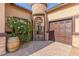 Exterior featuring barrel planters, secure gate entry and a private single car garage at 5576 Buena Martina Way, Las Vegas, NV 89141