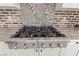 Close up of the kitchen's 6-burner gas range with stainless steel hood, granite counters, and brick backsplash at 5576 Buena Martina Way, Las Vegas, NV 89141